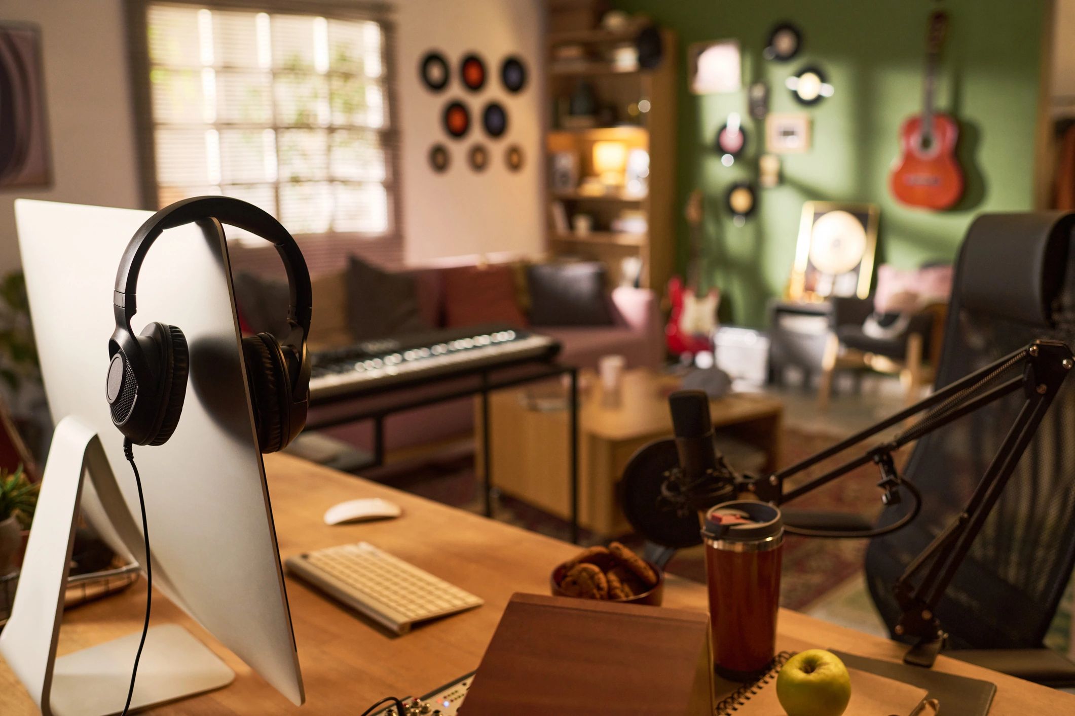 Podcast studio desk with computer and microphone